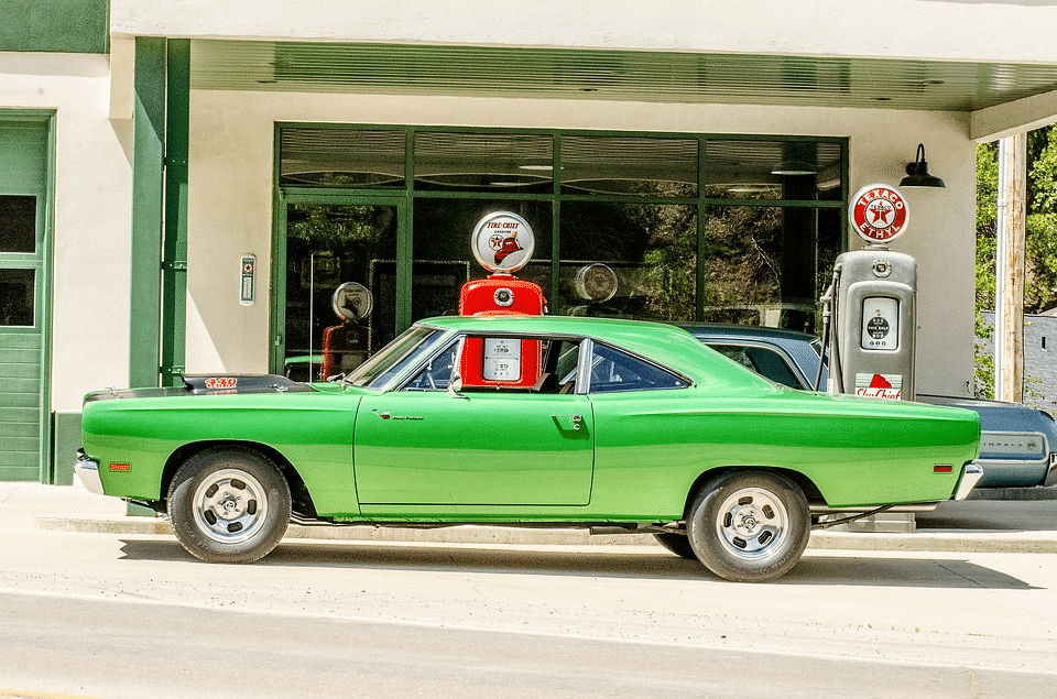 green car near gas station